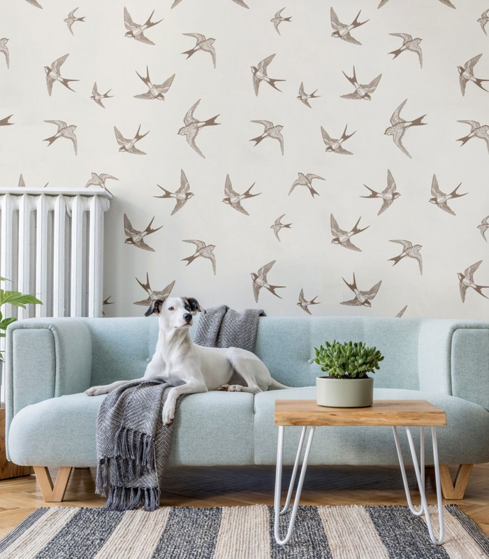 Tapeta Brown Swallow Wallcolors z motywem jaskółek w salonie nad sofą
