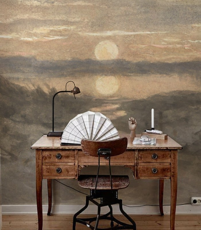 Tapeta Sunset Wallcolors – malarski pejzaż zachodzącego słońca na ścianie za biurkiem