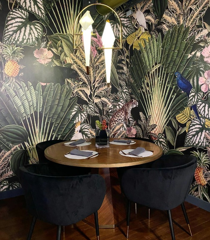 Tapeta Dark Jungle Wallcolors w restauracji przy okrągłym stole