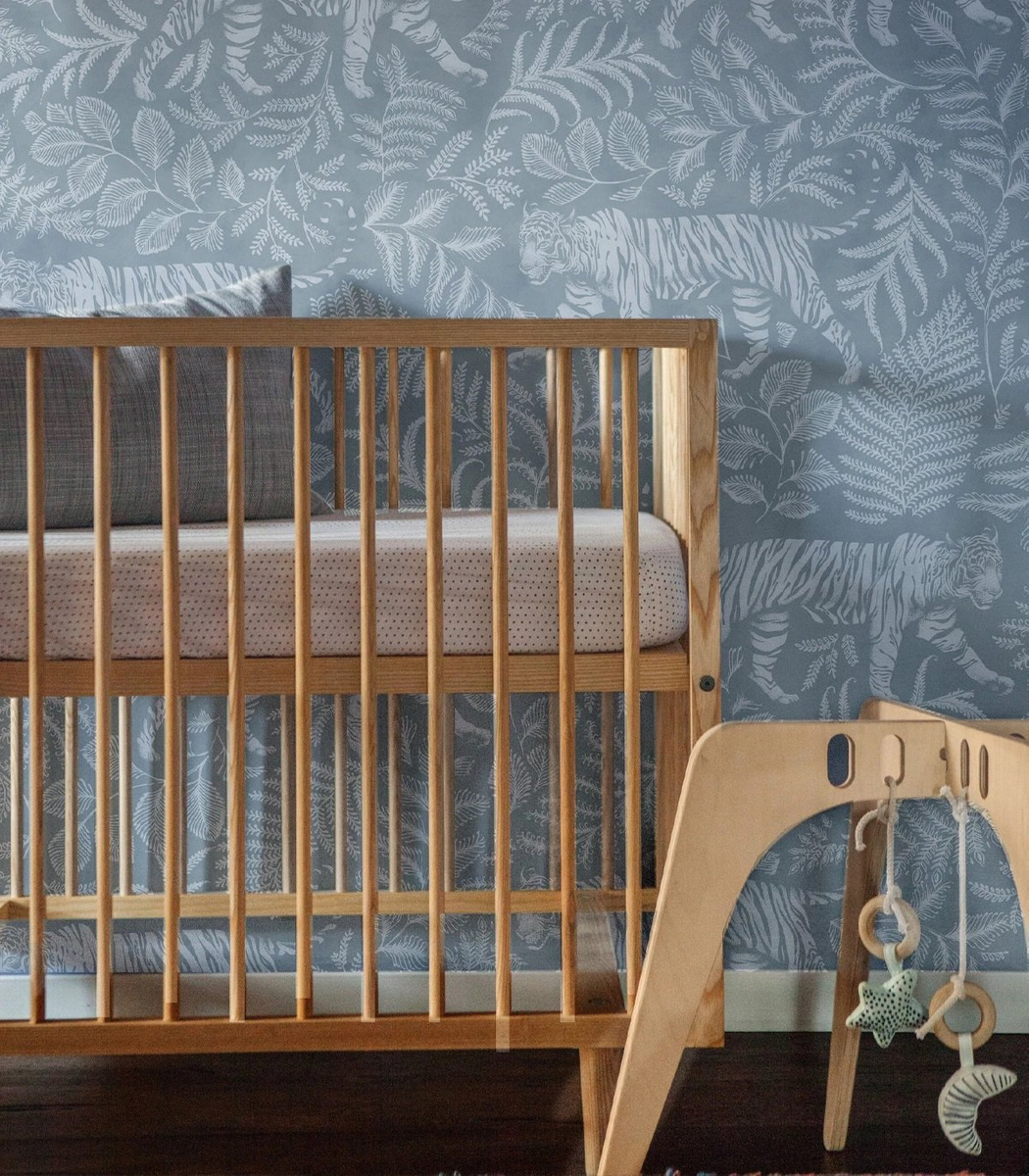 Tapeta Camouflaged Tiger Blue Wallcolors w pokoju dziecięcym za łóżeczkiem